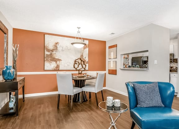 A blue leather chair sits in a room with orange walls at Paces Pointe Apartment Homes, Matthews