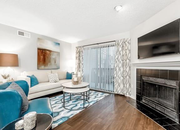 A living room with a fireplace and a television at Paces Pointe Apartment Homes, Matthews, NC, 28105
