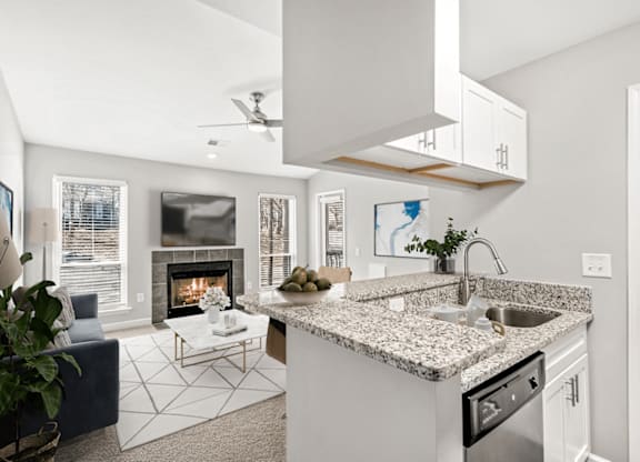 A modern kitchen with a fireplace and a blue sofa at Paces Pointe Apartment Homes, Matthews, NC, 28105