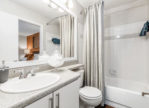 A white bathroom with a sink, toilet, and bathtub at Paces Pointe Apartment Homes, Matthews, NC, 28105