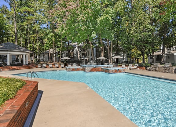 A pool surrounded by trees and a gazebo at Paces Pointe Apartment Homes, Matthews, NC, 28105