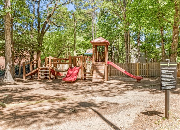 A playground with a red slide and a wooden structure at Paces Pointe Apartment Homes, North Carolina
