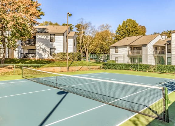 A tennis court is surrounded by apartment buildings at Paces Pointe Apartment Homes, North Carolina, 28105
