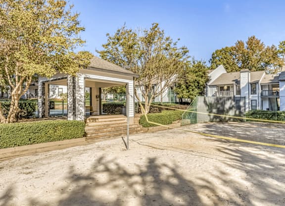 A building with a glass door and windows is surrounded by trees and a clear sky at Paces Pointe Apartment Homes, Matthews, 28105
