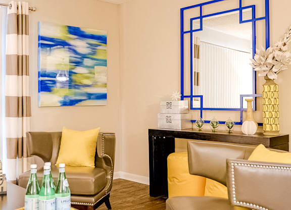 a living room filled with furniture and a large mirror at The Parke at Trinity Apartment Homes, North Carolina, 27607