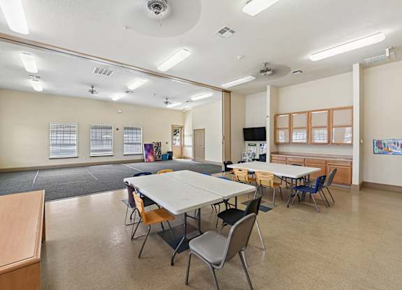 A classroom with tables and chairs and a whiteboard.