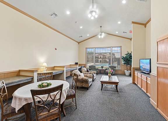 A spacious room with a table set for dining and a television.