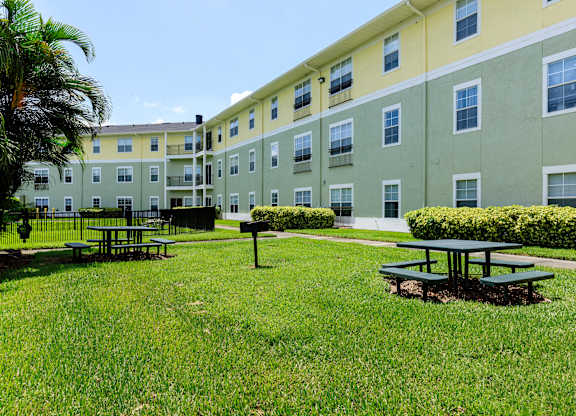 A green and yellow building with a picnic table in front.