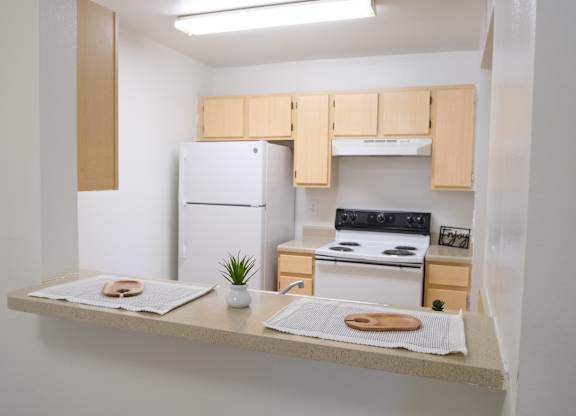 A small kitchen with a white fridge and a white oven.