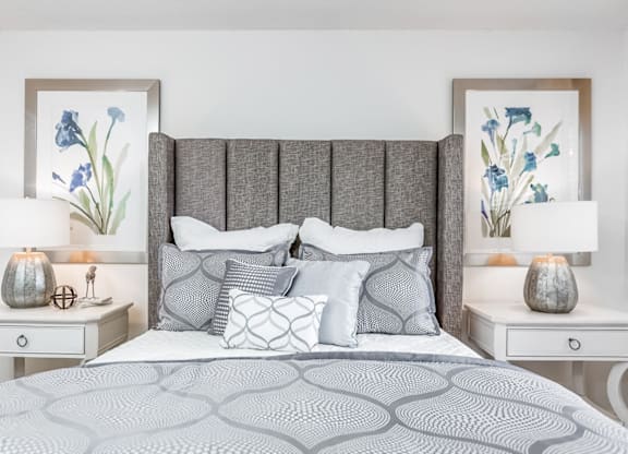 A bed with a grey headboard and a grey patterned bedspread at Regency Park Apartment Homes, Raleigh, North Carolina