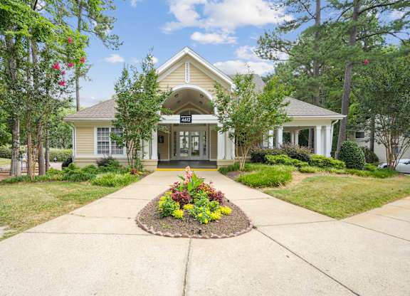 A house with a front yard and a flower bed in front of it at Regency Park Apartment Homes, Raleigh, NC