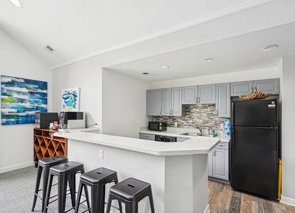A kitchen with a black fridge and white countertops at Regency Park Apartment Homes, Raleigh, 27616