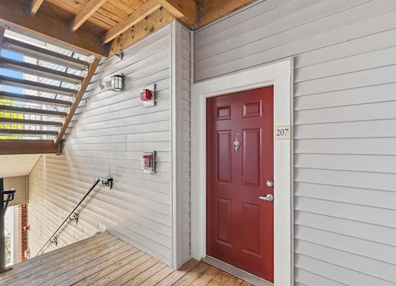 A red door with the number 207 on it.