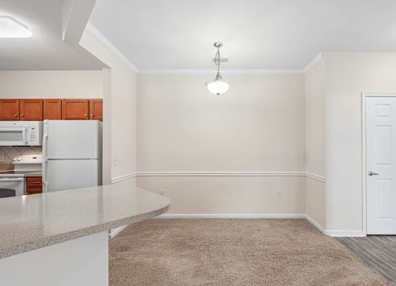A kitchen with a refrigerator, cabinets, and a countertop.