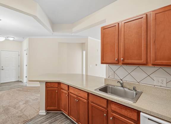 A kitchen with brown cabinets and a white sink.