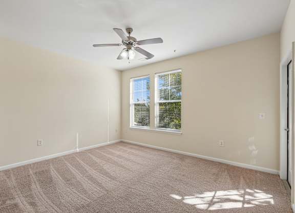 A room with a ceiling fan and a window.