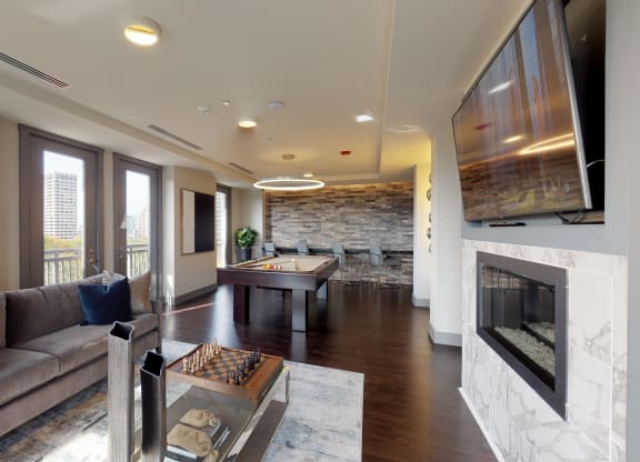 Resident sky lounge facing a pool table and sitting area complete with a television and fireplace.