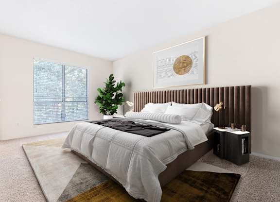 A bedroom with a large bed and a small tree.