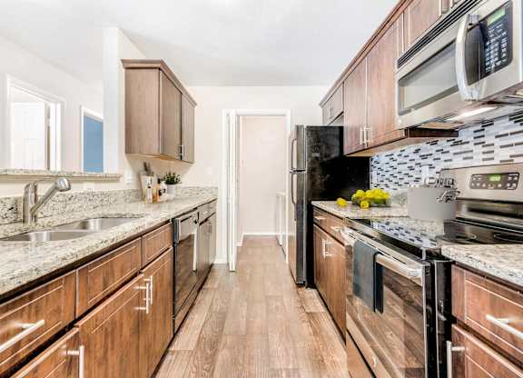 A kitchen with wooden cabinets and a black stove top oven.