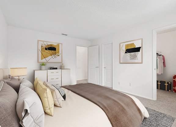 A bedroom with a large bed and two framed pictures on the wall.