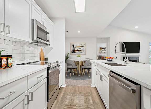 A modern kitchen with white cabinets and stainless steel appliances.