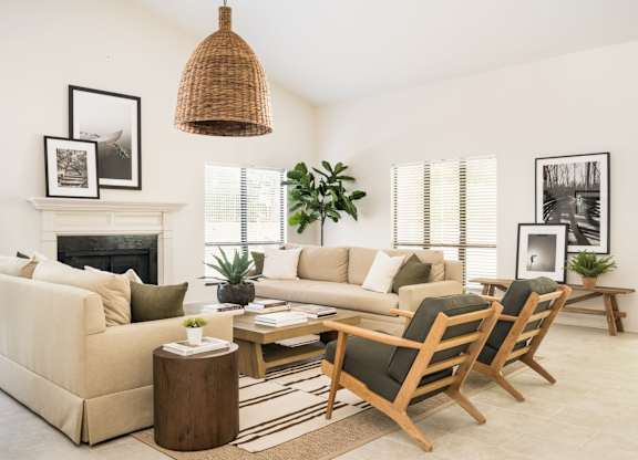 A living room with a fireplace, couches, and a rug.