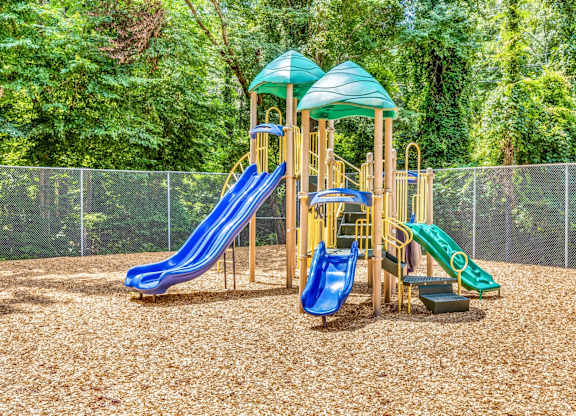A playground with a blue and green slide and a yellow structure.