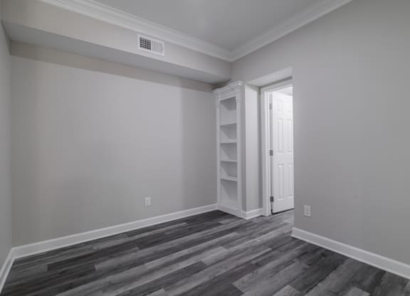 room with hardwood-style flooring and built-in shelving