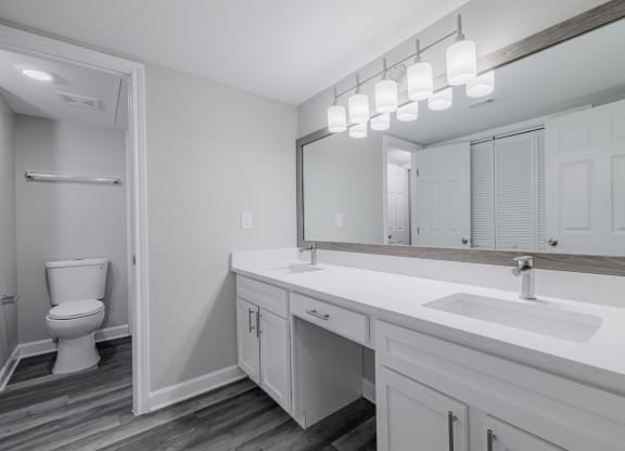 a bathroom with dual vanities, white countertops and cabinetrty