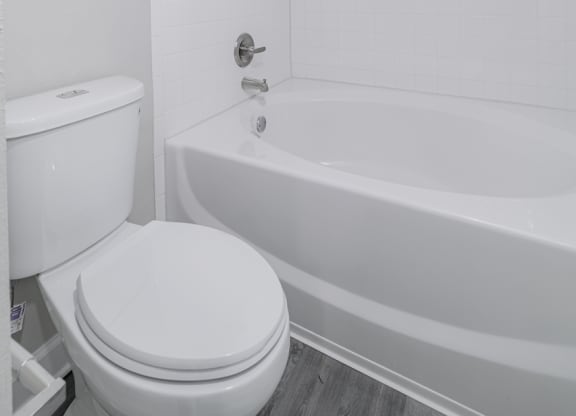 a white bathroom with a toilet and a tub