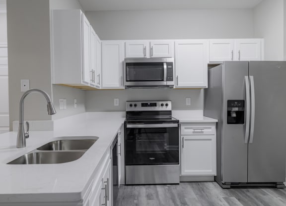 kitchen with stainless appliances, white countertops, and hardwood-style flooring
