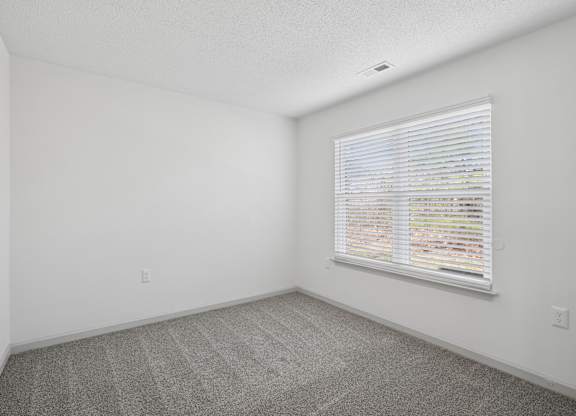 A room with a window covered in blinds.