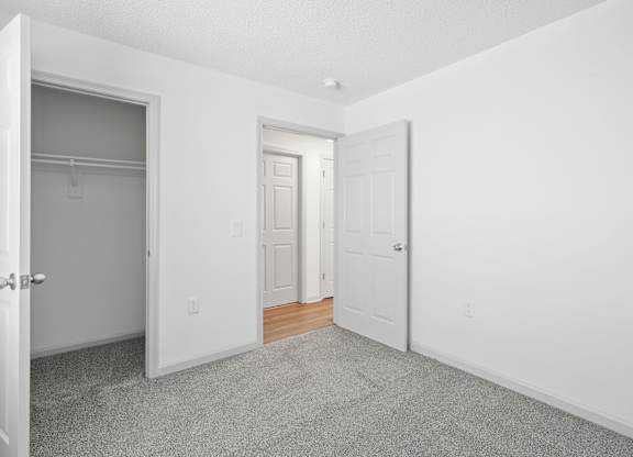 A white room with a carpeted floor and two doors.