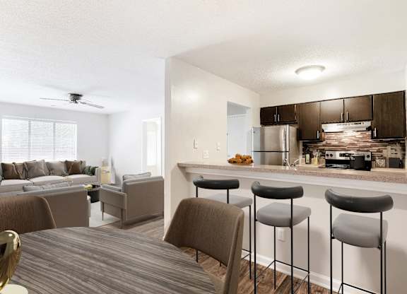 A modern kitchen with a bar stool and a dining table. at Woodlyn on the Green Apartment Homes, Cary, North Carolina