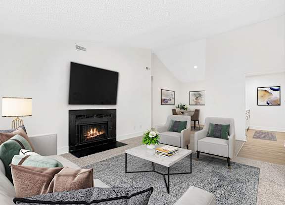 A living room with a fireplace and a couch. at Woodlyn on the Green Apartment Homes, Cary, North Carolina