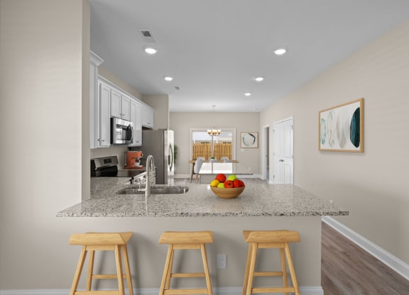 a kitchen with a counter top with three stools