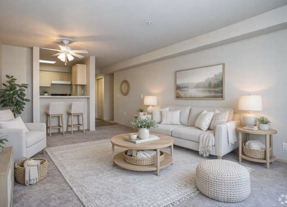 A living room with a white couch, a coffee table, and a ceiling fan.
