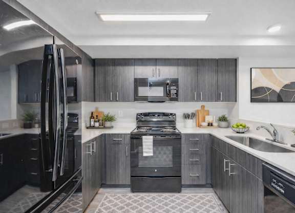 A modern kitchen with a black refrigerator and stove.
