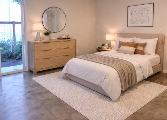 A bedroom with a large bed and a dresser with a mirror.