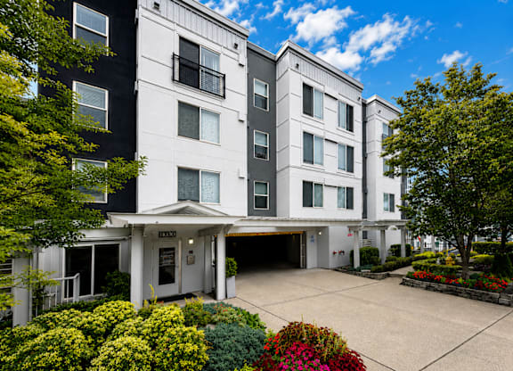 A large white and black building with a parking lot in front.