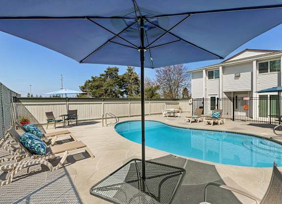 Resort Style Pool with Lounge Chairs and Shaded Bistro Set at Campo Basso Apartment Homes, Lynnwood, 98087