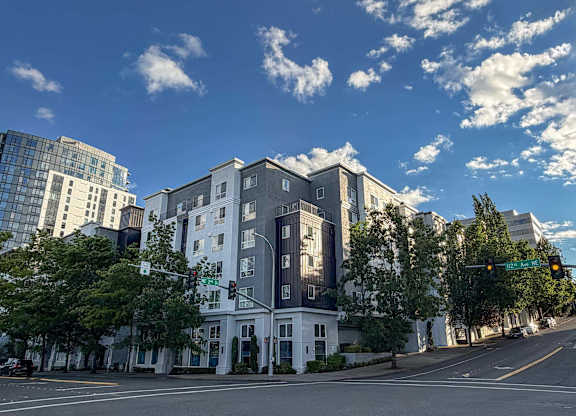 A street view of a white building with a green traffic light.