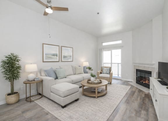 A living room with a fireplace, a couch, a chair, a coffee table, and a television.