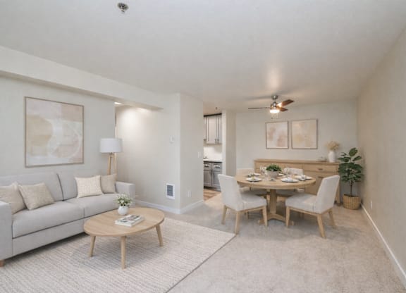 A living room with a couch, a coffee table, and a dining table with chairs.