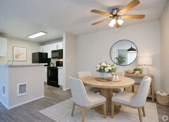 A dining room with a round table and chairs.