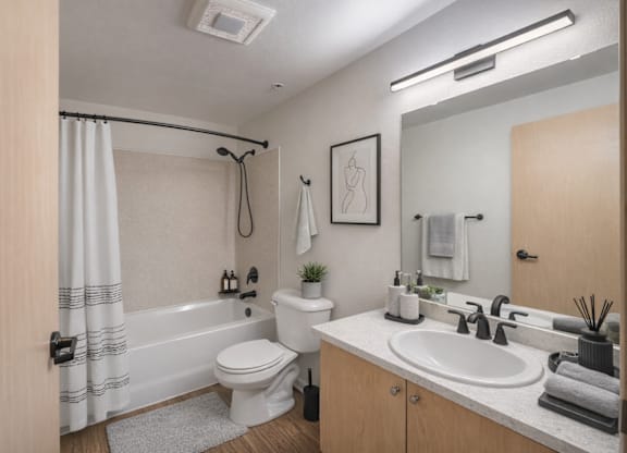 A bathroom with a toilet, sink, and shower.