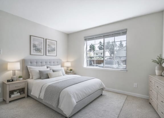 A bedroom with a large bed, nightstands, and a window overlooking a residential area.
