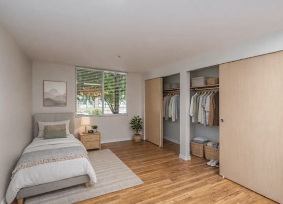 A bedroom with a bed, nightstand, and a wardrobe.
