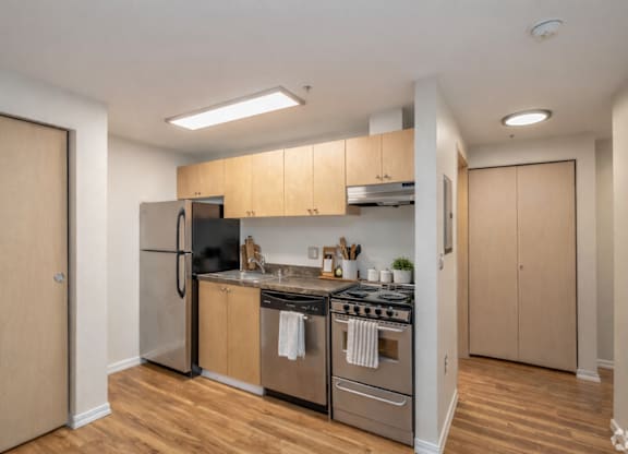 A kitchen with wooden floors and stainless steel appliances.