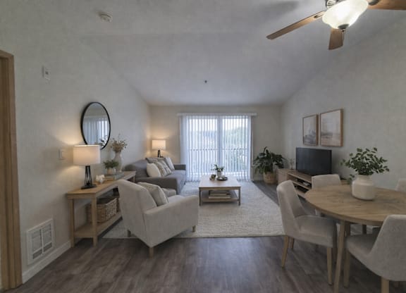 A living room with a grey couch, a wooden coffee table, and a television.